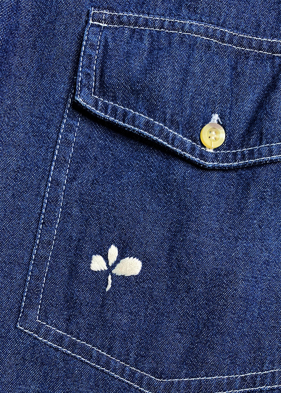 Close-up of pocket featuring hand embroidered flower.