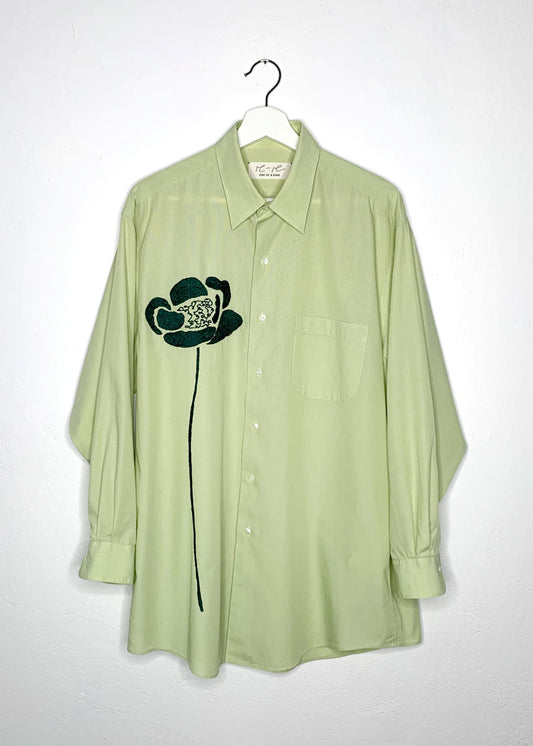Green shirt with hand embroidered green flower at front. 