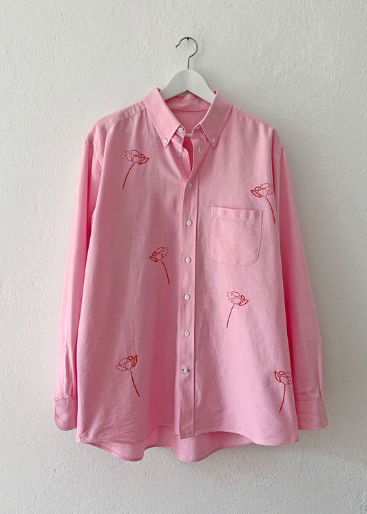 Pink shirt with hand embroidered red flowers.